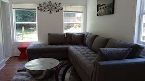 Relax in this stylish living room with a large sofa, coffee table, and decorative wall piece.