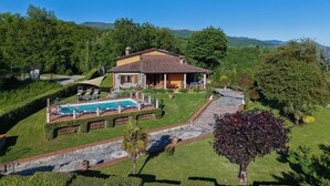 A house with a swimming pool, surrounded by a well-maintained garden and a stone pathway leading to the entrance. - Colle Santa Cristina, Castelnuovo di Garfagnana, Lucca and Viareggio (Castelnuovo di Garfagnana)