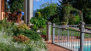 A garden with a pool, stone pillars, and a metal fence. - Colle Santa Cristina, Castelnuovo di Garfagnana, Lucca and Viareggio (Castelnuovo di Garfagnana)