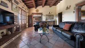 A living room with a TV, leather sofa, and a coffee table. - Colle Santa Cristina, Castelnuovo di Garfagnana, Lucca and Viareggio (Castelnuovo di Garfagnana)