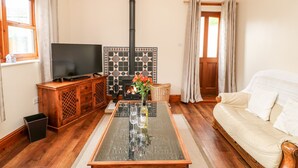 A cozy living room with a fireplace, a television, a sofa, and a coffee table.