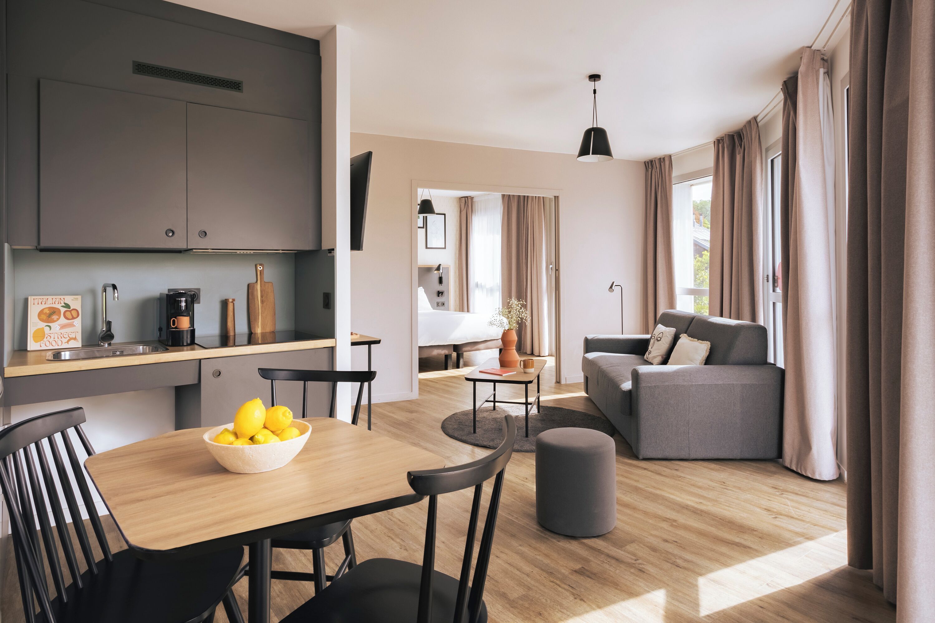 A modern kitchen with a dining area, a sofa, and a coffee table.
