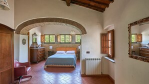 Une chambre à coucher avec un lit, une commode, un miroir et un radiateur.