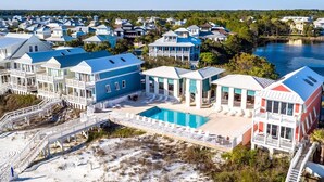 A coastal residential area with multiple houses, a swimming pool, and a beach.