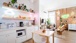 Et moderne køkken med hvide skabe, en mikrobølgeovn og et skilt, der siger 'Welcome to Neon'.