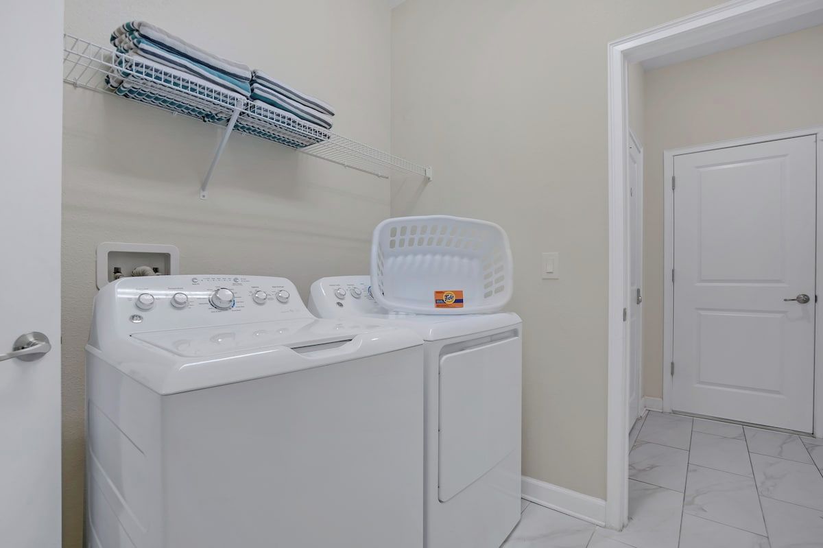 A laundry area with a washing machine, dryer, and a drying rack.
