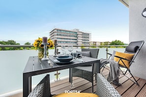 Enjoy a romantic dinner for two on the balcony, surrounded by a beautiful view of the water and a vase of sunflowers.