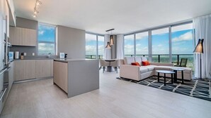 Una sala de estar moderna con sofá, comedor y cocina.