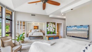 A spacious bedroom with a large bed, a ceiling fan, and a view of a beach through a large window. - Napili Gardens B7 3 Bedroom 3 Townhouse by RedAwning (Lahaina)