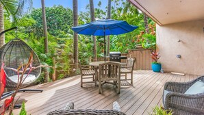 A wooden deck with a table and chairs, a hanging chair, and a grill area. - Napili Gardens B7 3 Bedroom 3 Townhouse by RedAwning (Lahaina)
