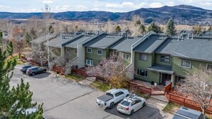 A residential area with multiple two-story houses, a parking lot, and a mountainous backdrop. - Whistler Village - Redwood 10 2 Bedroom Condo by RedAwning (Steamboat Springs)