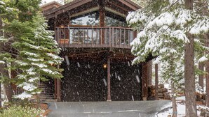 A wooden cabin with a balcony, surrounded by snow-covered trees. - Beautiful 3-Bedroom Contemporary Mountain Home in Northstar by RedAwning Save 10% on 3 Nights, 15% on 5 Nights! (Truckee)