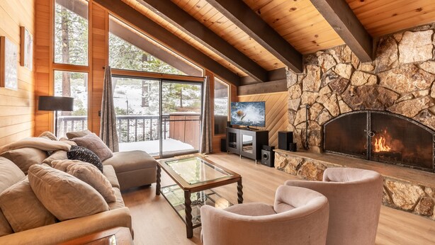 A cozy living room with a stone fireplace, large windows, and a comfortable seating area. - Beautiful 3-Bedroom Contemporary Mountain Home in Northstar by RedAwning Save 10% on 3 Nights, 15% on 5 Nights! (Truckee)