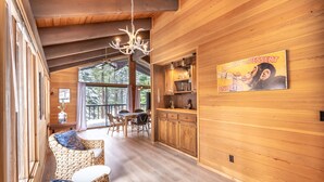 A wooden interior with a dining area, kitchen, and large windows. - Beautiful 3-Bedroom Contemporary Mountain Home in Northstar by RedAwning Save 10% on 3 Nights, 15% on 5 Nights! (Truckee)