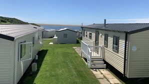 Filas de viviendas modulares con césped y vista al agua.