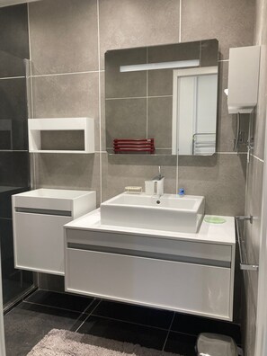 Een douche, een haardroger, handdoeken, toiletpapier