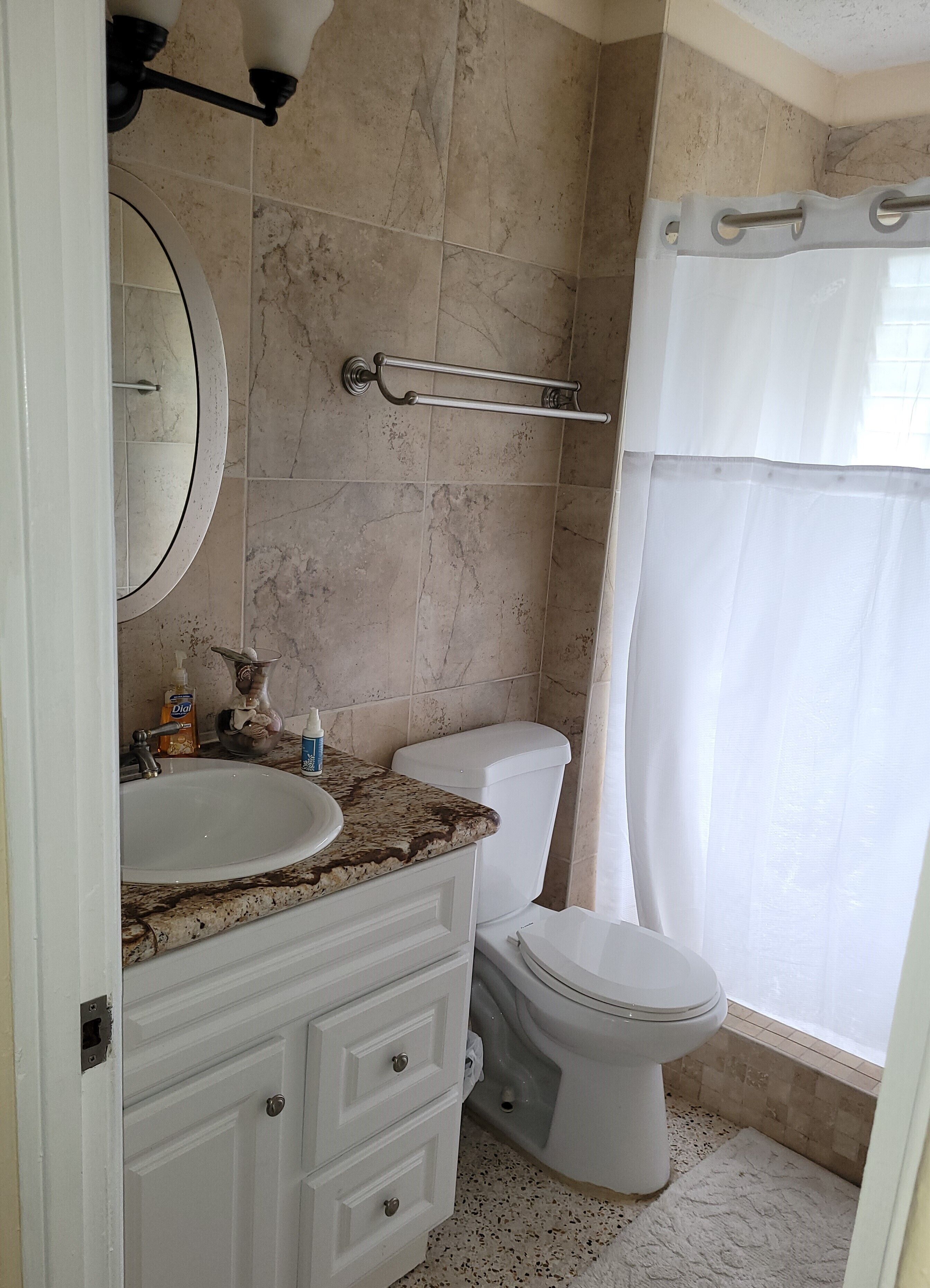 Un bagno con lavabo in marmo, un water e una tenda per la doccia.