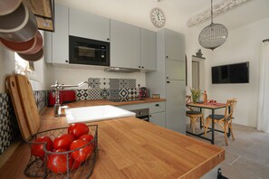 Une cuisine moderne équipée d’un four à micro-ondes, d’un évier et d’un coin repas avec des chaises et une table.