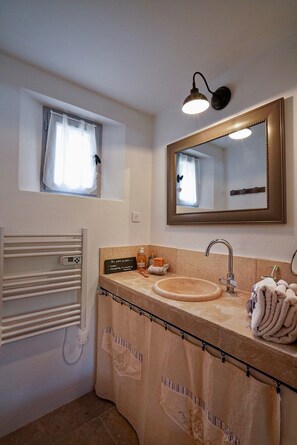 A bathroom with a sink, mirror, towel rack, and a window with curtains. - Cottage-Ensuite with Bath-Garden view-Cottage Mirabeau (Aix-en-Provence)