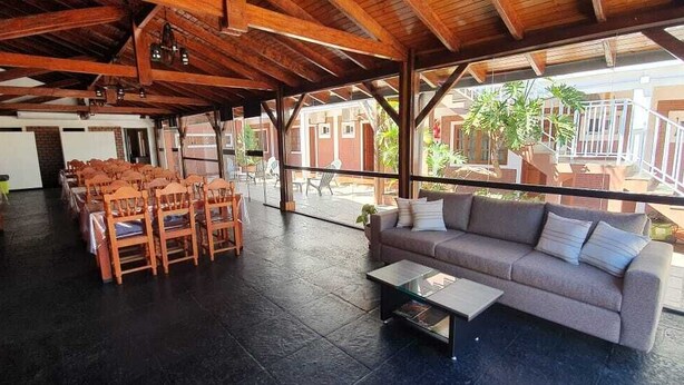 Un espace ouvert avec un plafond en bois, un canapé et plusieurs chaises disposées pour créer un coin salon.