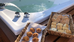 Une terrasse en bois avec un jacuzzi et deux paniers remplis de produits de boulangerie.