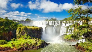 Une cascade à plusieurs niveaux, entourée d’une végétation luxuriante et d’un paysage rocheux.