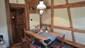 Un comedor rústico con una mesa de madera, bancos y una lámpara colgante.