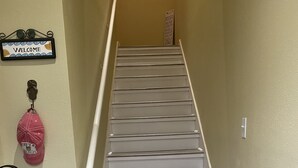A staircase with white steps and a wooden handrail. - Breezy Beach Retreat (Gulfport)
