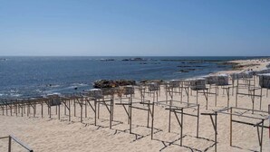 Una spiaggia con strutture metalliche, probabilmente per prendere il sole, e una vista limpida sul mare.