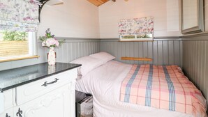 Un dormitorio con cama, cómoda, ventana con vistas y ventilador de techo.