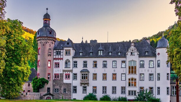 Un edificio grande e histórico con una torre destacada y numerosas ventanas.