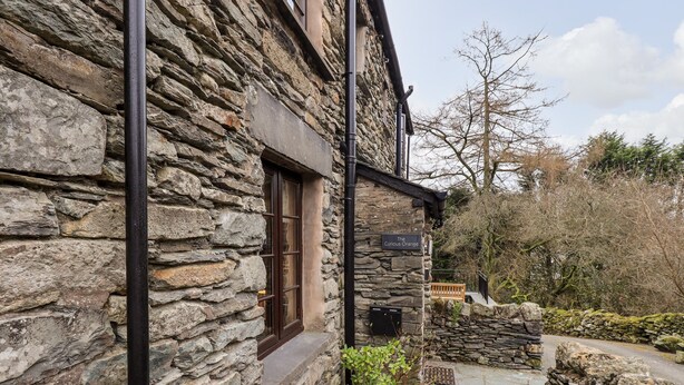 A stone building with a sign reading "The Curious Orange." - The Curious Orange (Windermere)