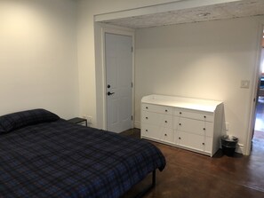 A bedroom with a bed, a dresser, and a door. - Lakefront, Beach, Fishing, Hot Tub, Gated, Fire Pit (Denver)