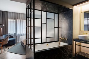 A modern bathroom with a large bathtub, a separate shower area, and a vanity with a sink.
