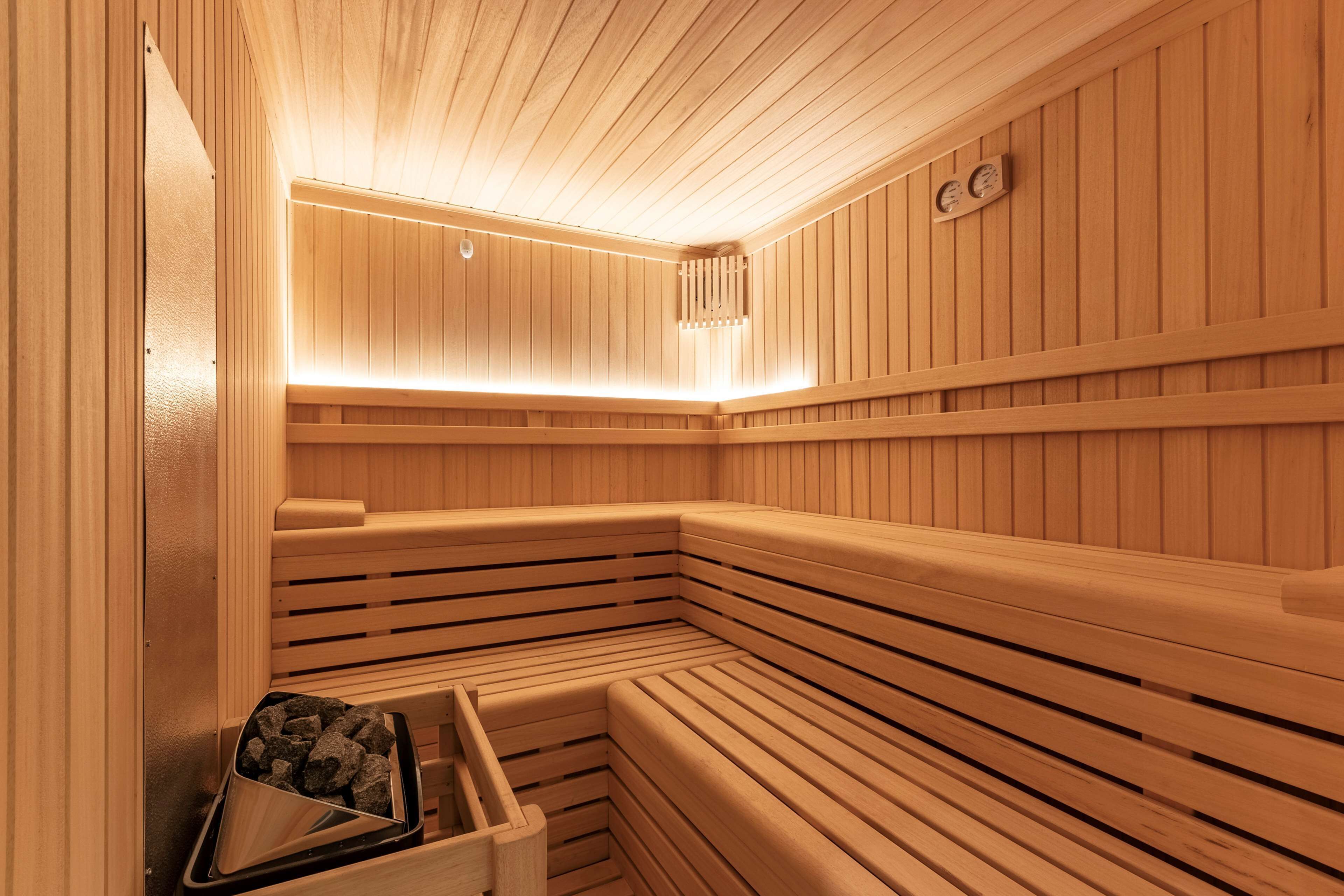Een sauna met houten banken en een bankverwarmer.