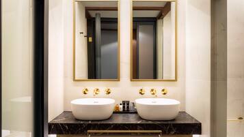 Un baño con dos lavamanos, un espejo y una puerta.
