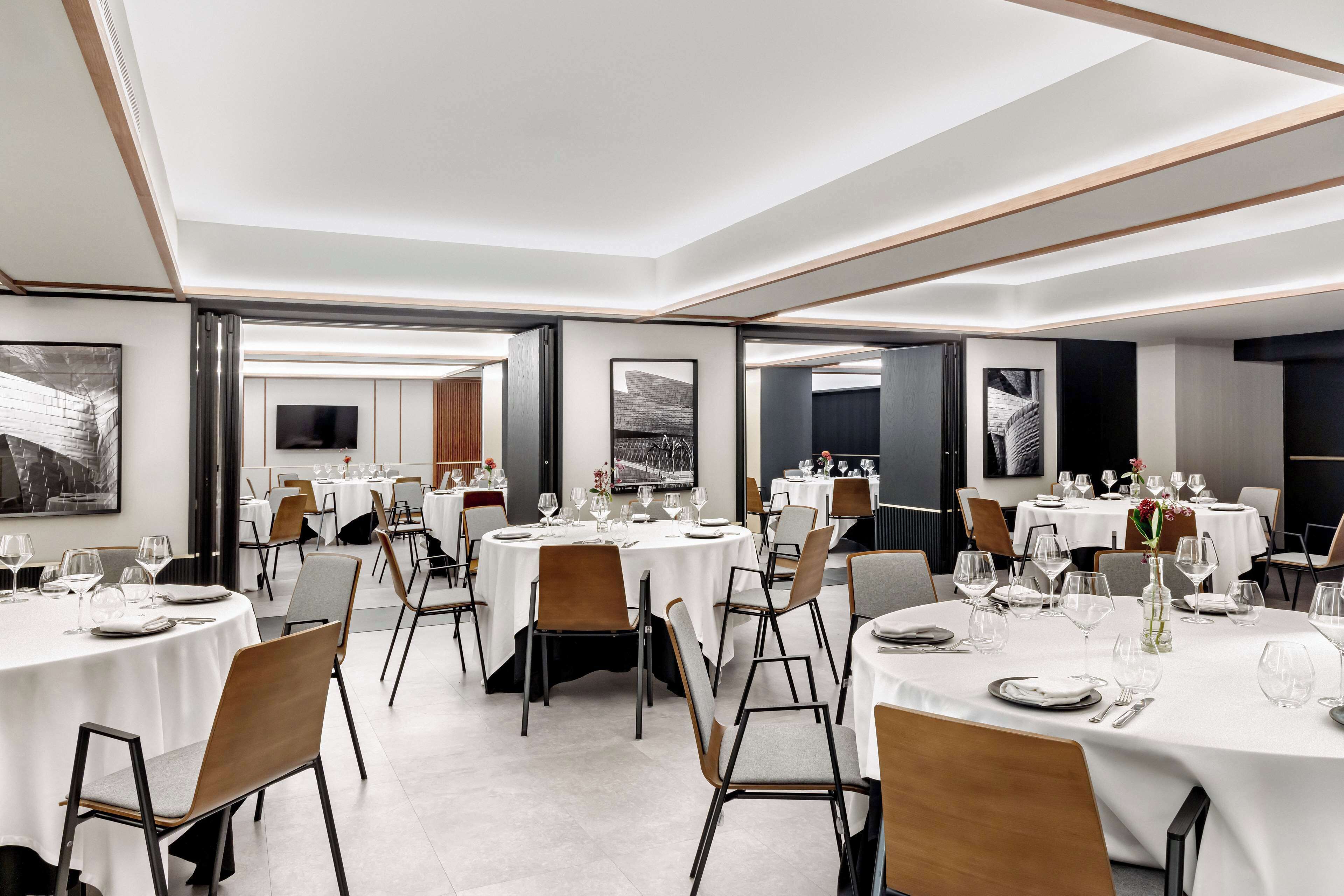 A modern dining area with round tables, chairs, and a minimalist decor.
