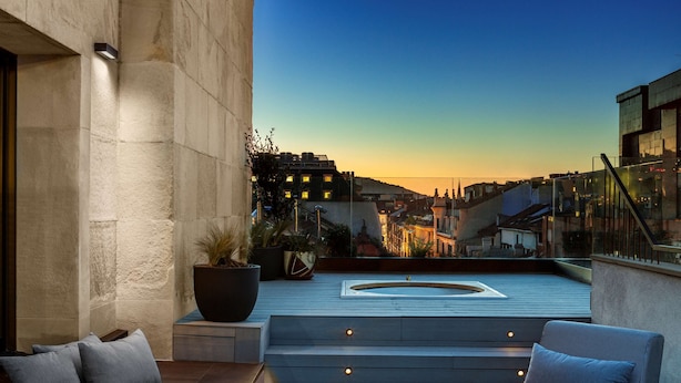 A rooftop terrace with a pool, seating area, and city views at dusk. - Radisson Collection Bilbao (Bilbao)