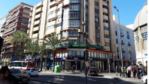 Un edificio de varios pisos con locales comerciales en la planta baja, que incluyen una clínica y una farmacia.