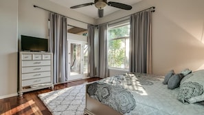 A bedroom with a bed, a TV on a dresser, and a sliding glass door leading to a balcony. - North Scottsdale Sanctuary w/ Htd Pool and Views (Scottsdale)