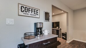 Eine moderne Küche mit einer Kaffeestation, einem Fernseher und einer gemütlichen Sitzecke.