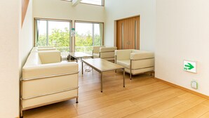 Una habitación de hotel moderna con sofá, sillas, una mesa y vistas al exterior.