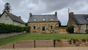 A stone house with a grassy yard and a gravel path leading to the entrance. - Maison Dans une Ancienne Ferme sur 3,5ha (Plougonver)