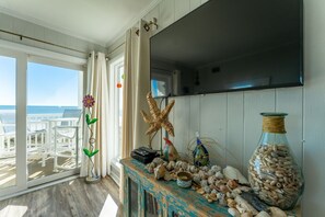 Enjoy the ocean view from this seaside retreat, featuring a console table with nautical decor and a flat-screen TV.
