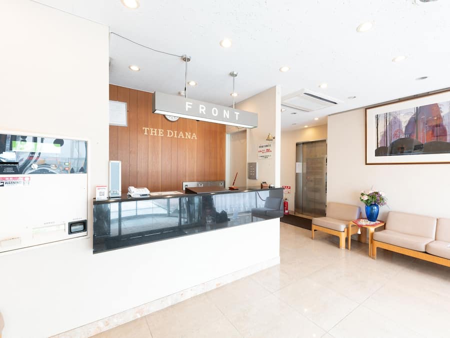 A reception area with a wooden counter, a sofa, and a painting on the wall.
