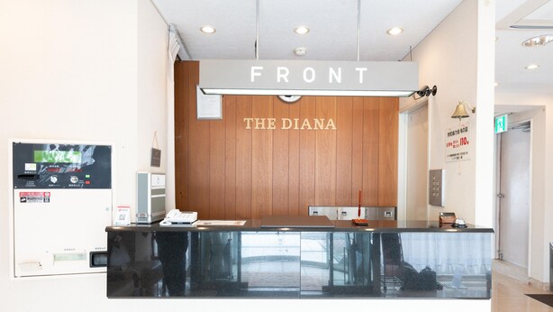 Un comptoir d’accueil avec un panneau en bois et une enseigne indiquant « FRONT THE DIANA ».