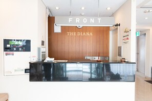Un comptoir d’accueil avec un panneau en bois et une enseigne indiquant « FRONT THE DIANA ».