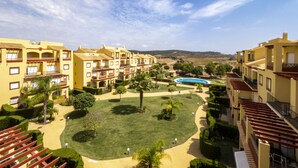 Ein Resort mit mehreren gelben Gebäuden, einem Schwimmbad und gepflegten Gärten.