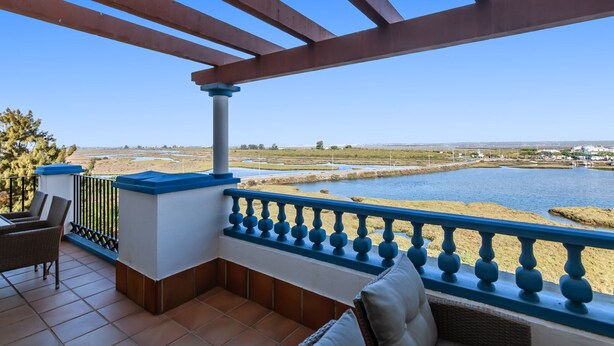 A balcony with a view of a river and distant landscape. - Marina III - Marina Isla Canela PMHIII37P5 (Punta del Moral)