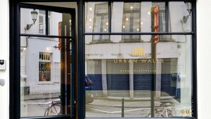 A building with a large glass window displaying the text "URBAN WALLS Urban Guesthouse." - Urban Walls (Brussels)